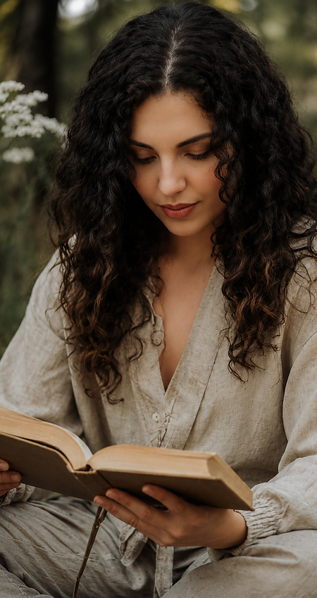 mulher branca cabelos longos e cacheados, sentada lendo um livro.