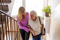 Femme-senior-montant-les-escaliers-avec-jeune-fille