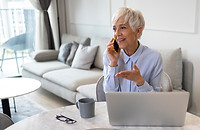 Femme-senior-au-téléphone-devant-ordinateur