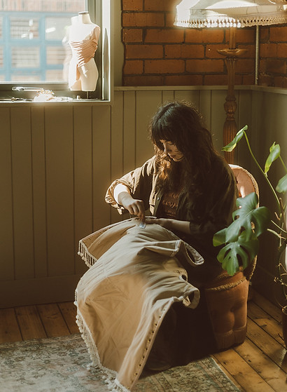 Designer Ruth Bronwen Bridge hand sewing a wedding dress in her Manchester (UK) bridal studio.