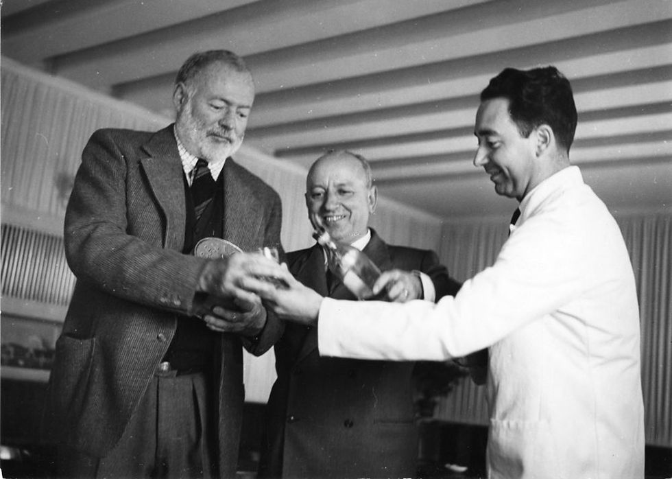 Ernest Hemingway, Giuseppe Cipriani, and barman Ruggero Caumo with wine at Harry's Bar, Ve