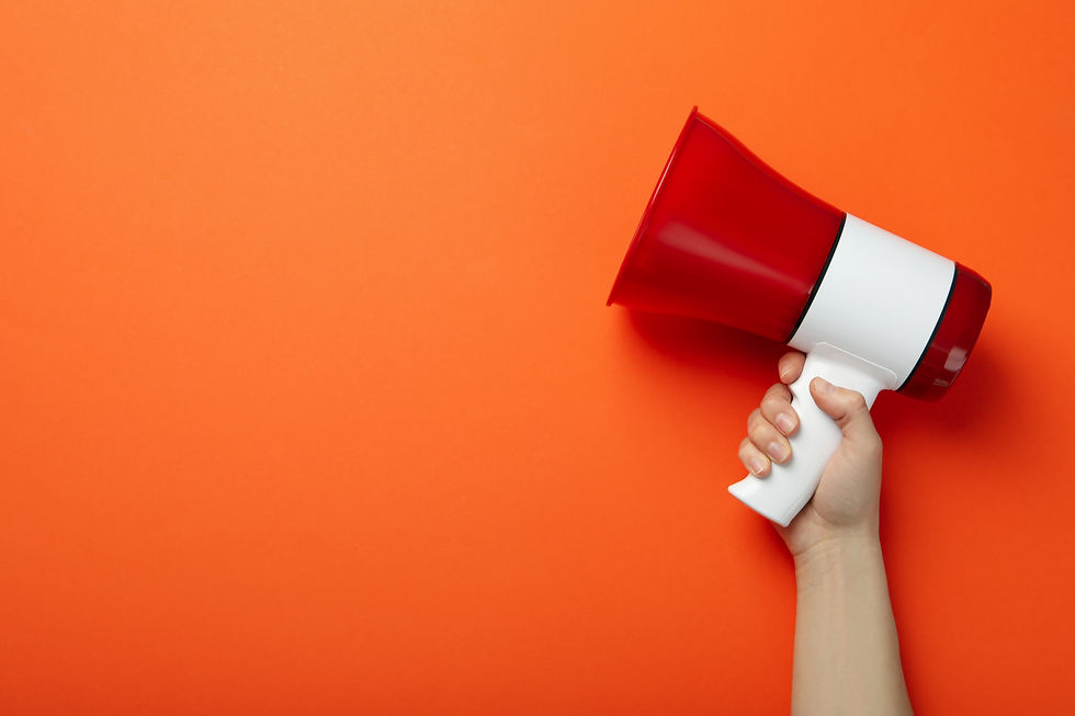 Hand holding a red and white megaphone against a bright orange background, conveying urgency and attention.