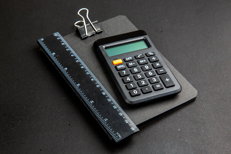 Calculator on a clipboard with a black ruler and binder clip. Black background, simple setup, no visible text on screen.