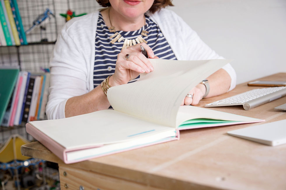 picture shows woman turning page of notebook
