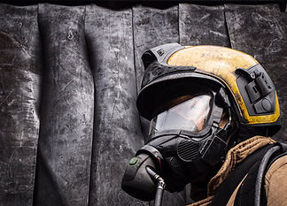 Close up photo of a firefighter wearing a helmet and an oxygen mask