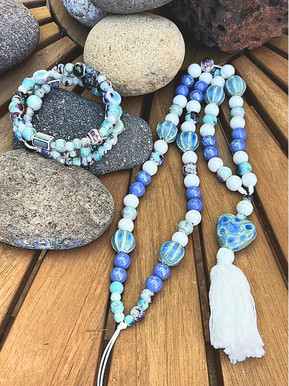 Collar largo artesanal con cuentas de cerámica azul y blanca, corazón y borla de algodón. Pulsera a juego.