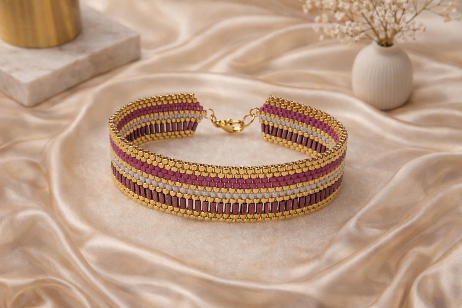 Pulsera Kenza de joyería de autor tejida a mano con delicas Miyuki en tonos granate, oro y blanco perlado con cierre de acero