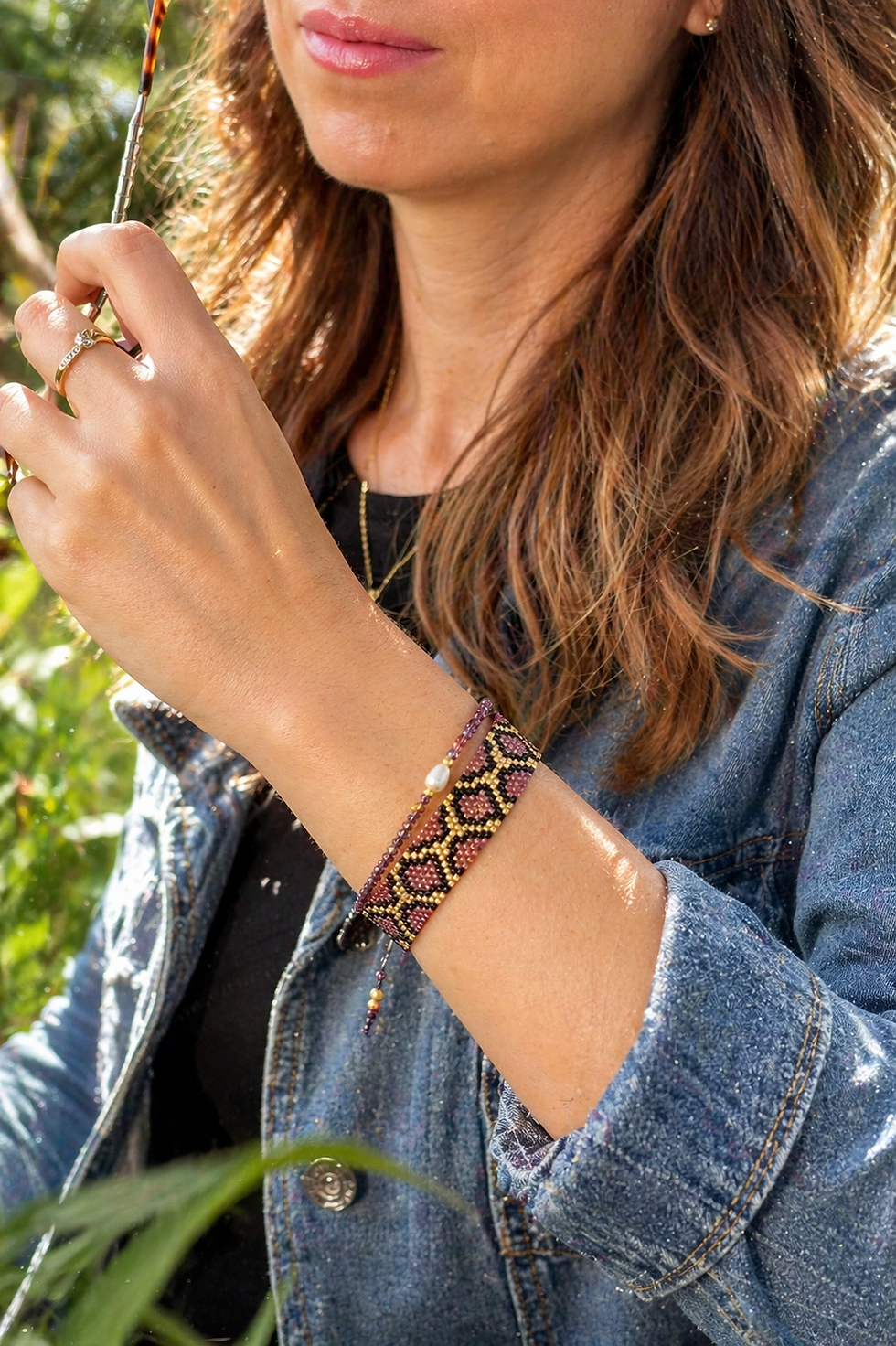 Miniatura: Mujer luciendo la pulsera artesanal Boa. Diseño de cuentas Miyuki en color rosa dorado, ideal para un look casual y elegante.
