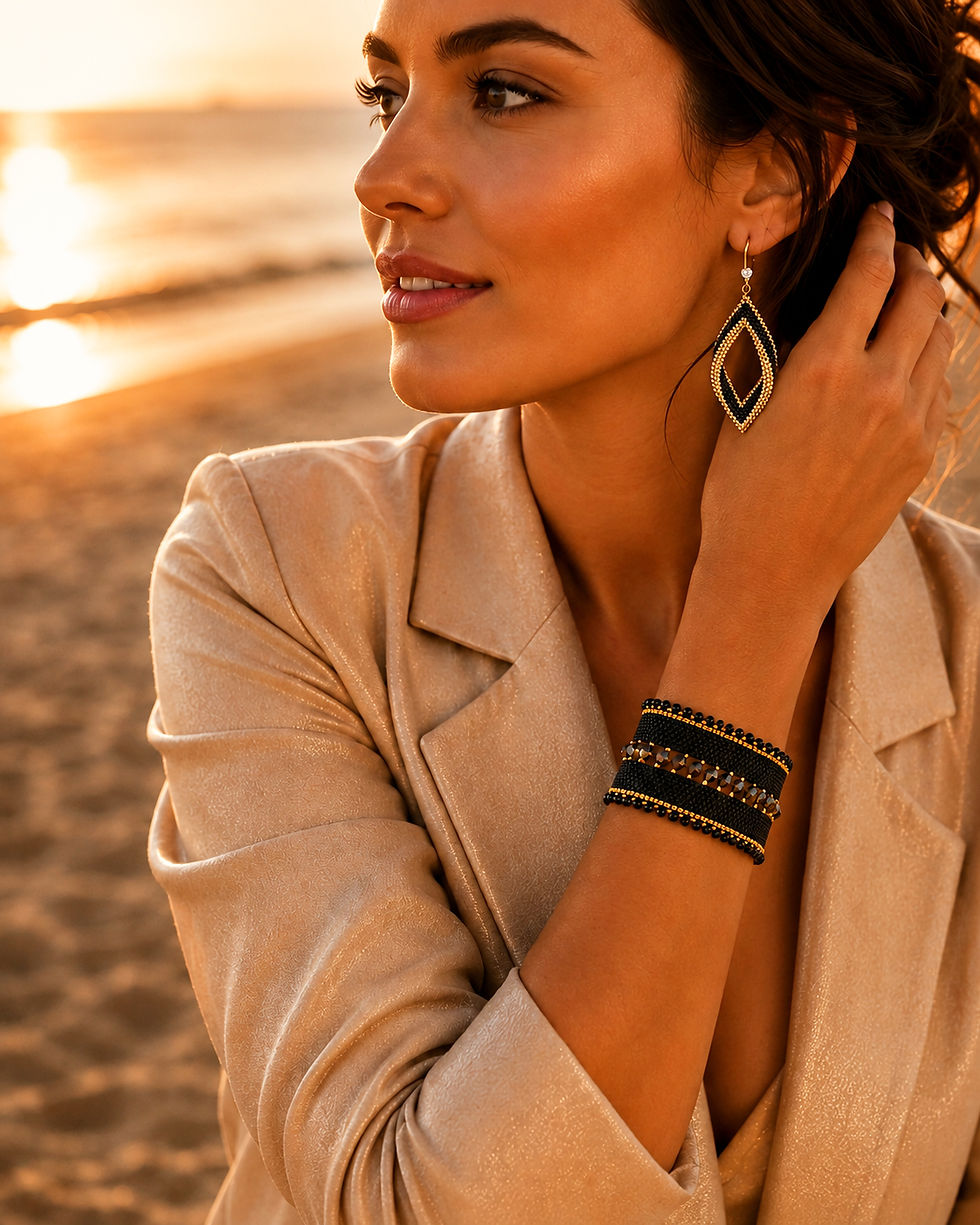 Mujer luciendo el brazalete Osiris negro y los pendientes Belle de Pulsereamos, joyas artesanales hechas a mano en España con cuentas Miyuki tejidas y acero hipoalergénico dorado. Un conjunto de joyería mediterránea ideal para un look de invitada perfecta estilo boho chic en un evento de tarde.