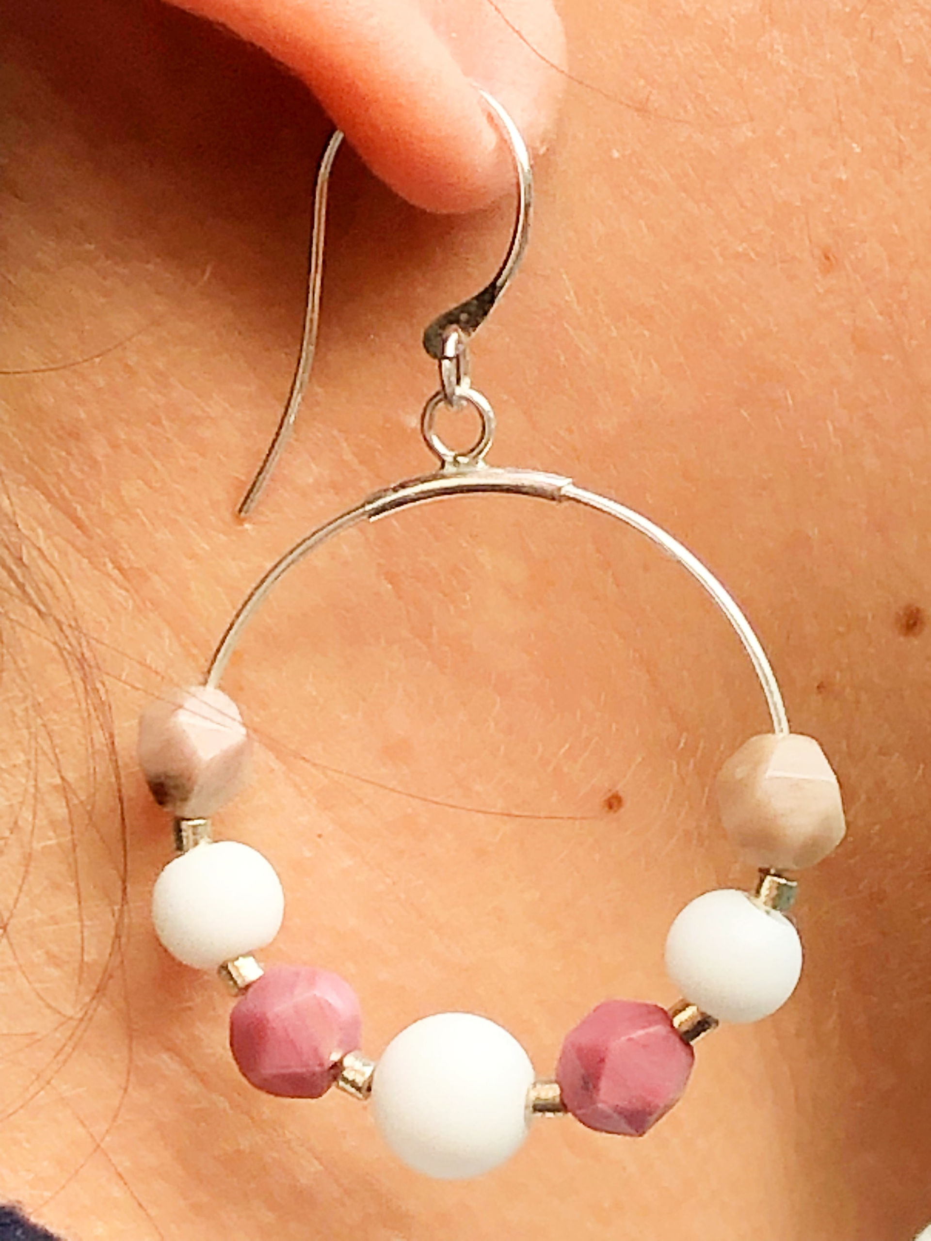 Pendientes Aro Rodocrosita hechos a mano con piedras naturales, incluyendo ágatas blancas y rodocrosita, montados en plata de ley. Su diseño en forma de aro combina elegancia y sofisticación, ideal para quienes buscan un accesorio exclusivo y artesanal con el poder de las piedras naturales.
