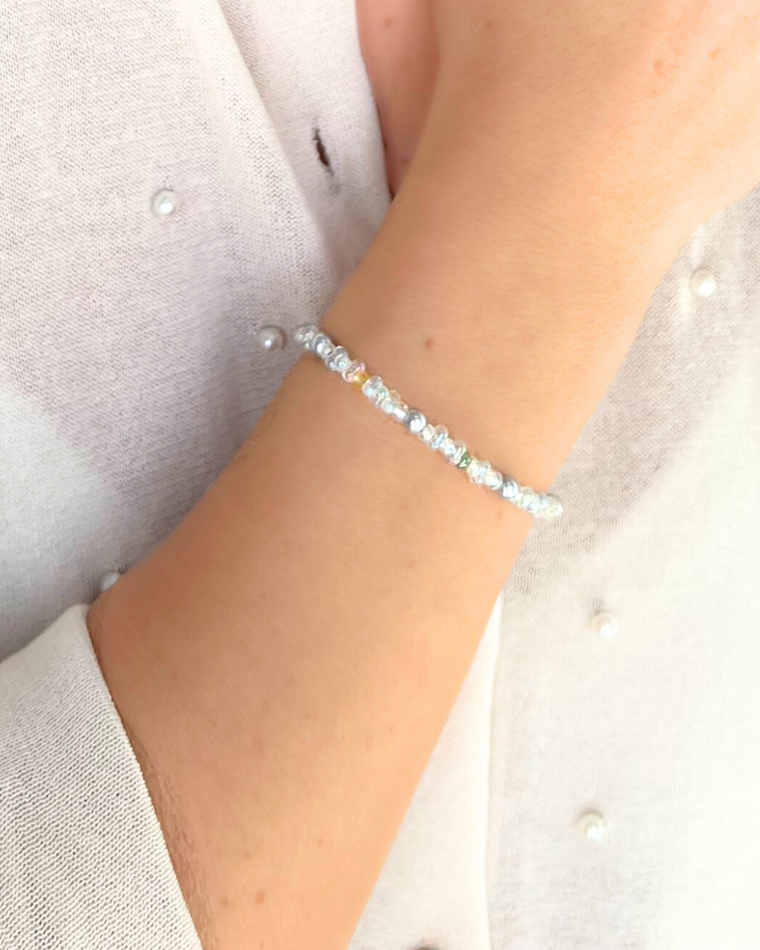 Detalle de pulsera artesanal para invitadas Kyara hecha a mano con cuentas de cristal Miyuki y perlas blancas sobre piel.