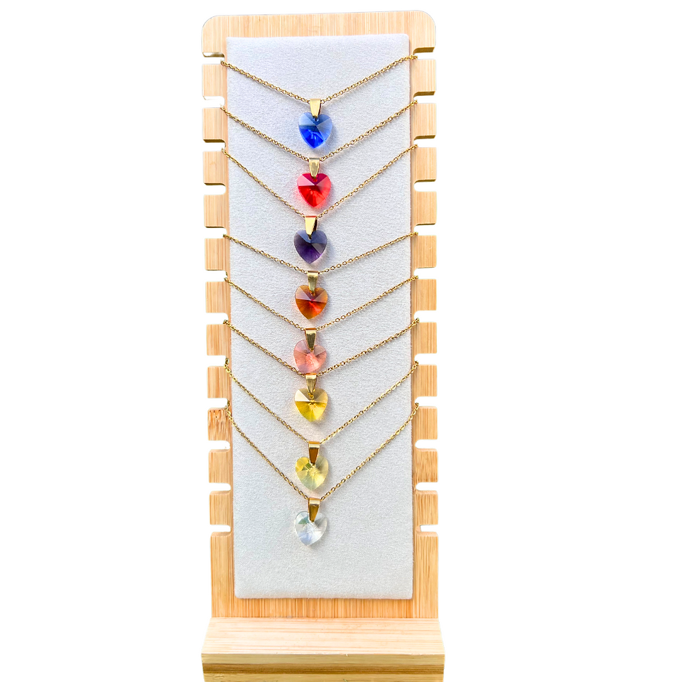 Colgantes Cuore hechos a mano con cadena de acero hipoalergénico y colgante en forma de corazón de cristal checo. Disponibles en varios colores, desde tonos suaves como rosa y dorado hasta vibrantes como rojo y azul. Una joya elegante y versátil, ideal para expresar amor y estilo con un diseño único y artesanal.