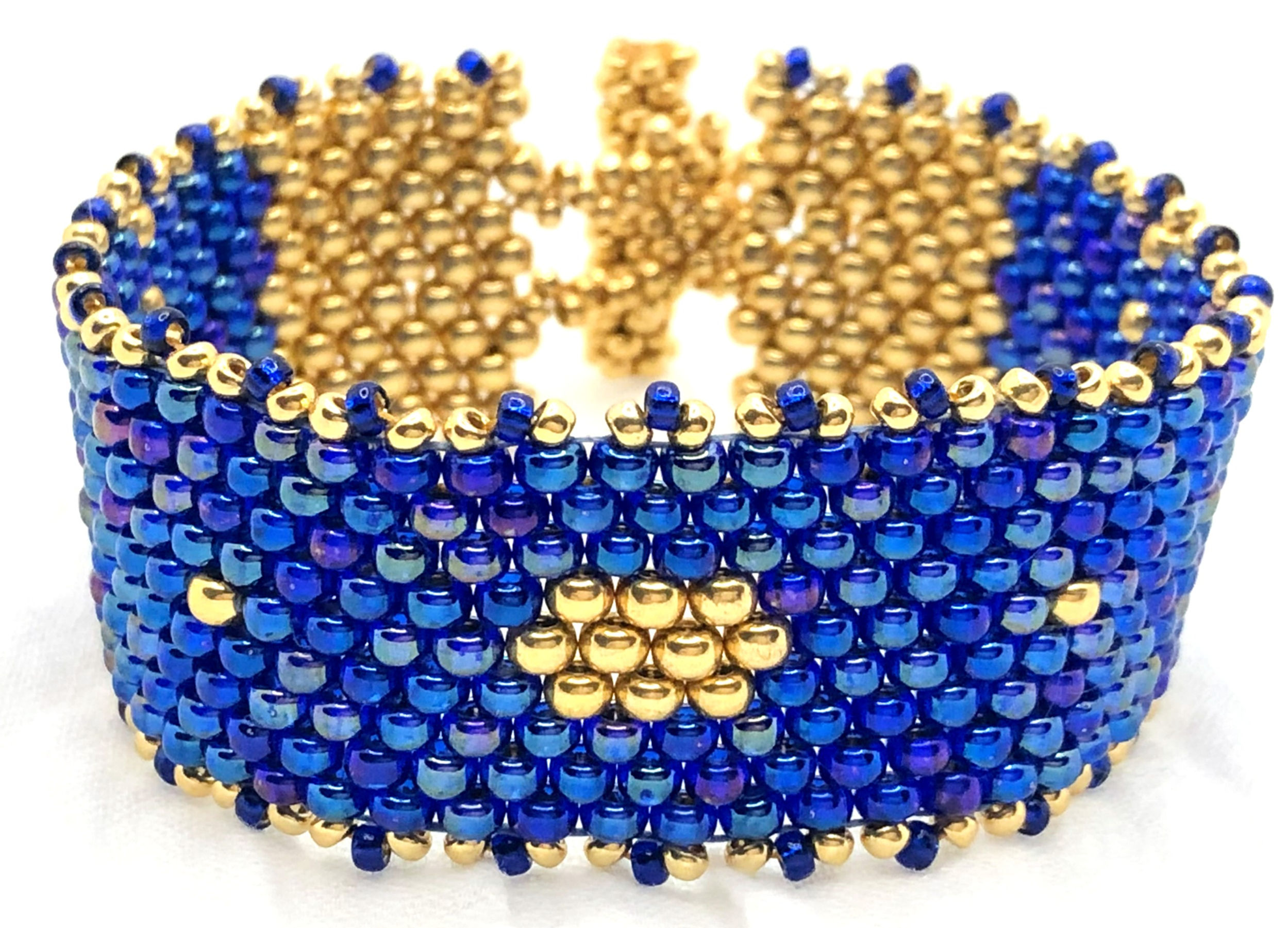 Pulsera artesanal azul y dorada tejida con cuentas Miyuki, diseño boho elegante y cierre ajustable dorado.