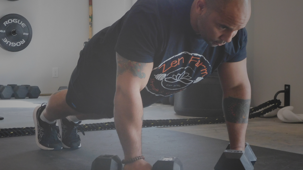 man doing a high plank on weights