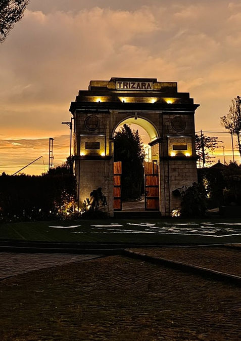 Illuminated ornamental arch beneath an orange evening sky at Trizara.