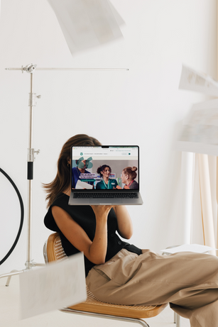 Woman holding laptop showing NAATI website