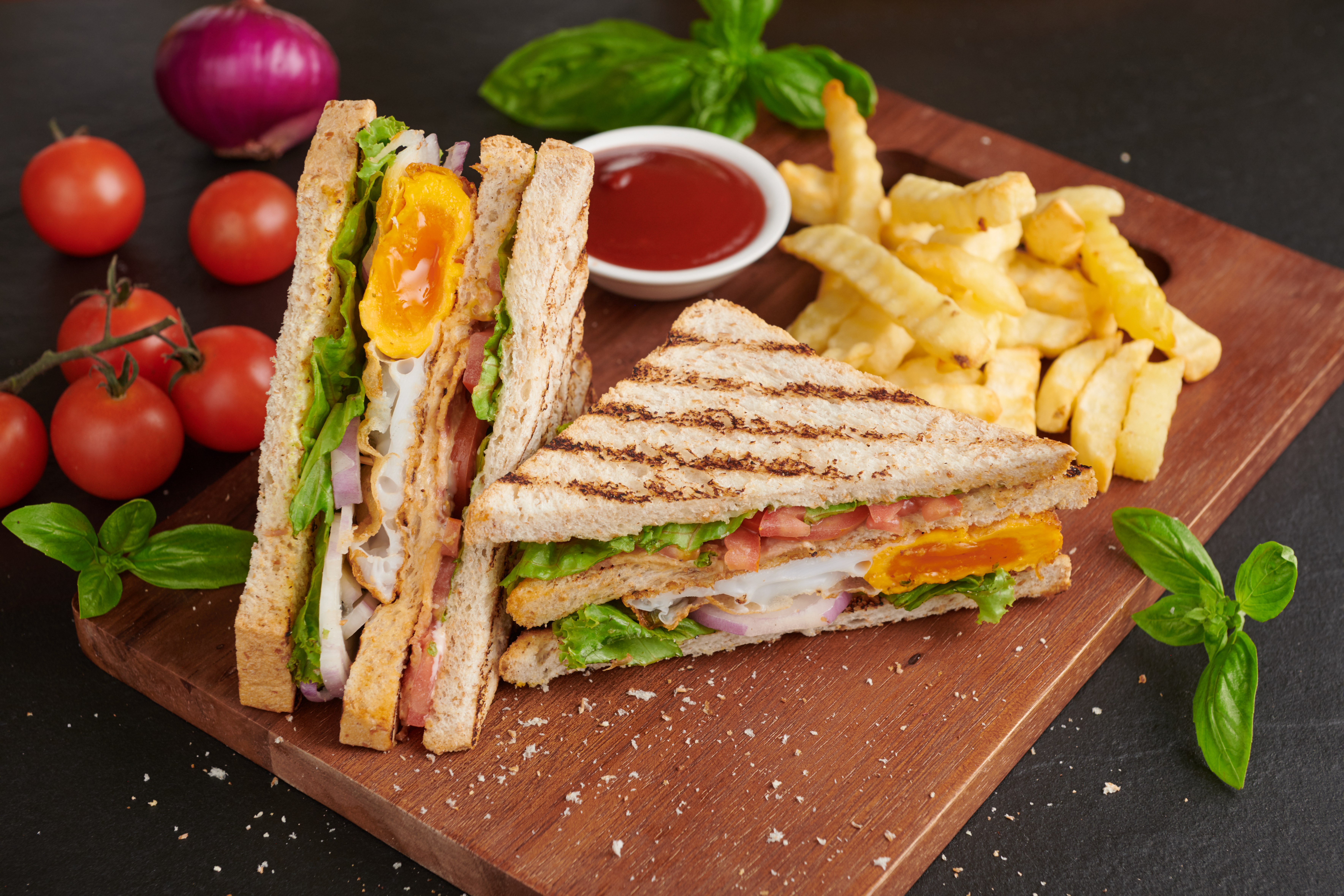 grilled-sandwich-with-bacon-fried-egg-tomato-lettuce-served-wooden-cutting-board.jpg