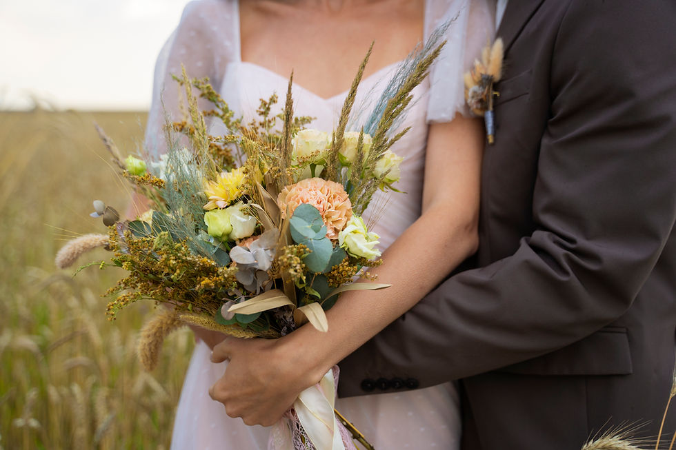 Braut hält Blumenstrauß, Bräutigam umarmt sie, Hochzeitsfoto, Natur, Gras Hintergrund.