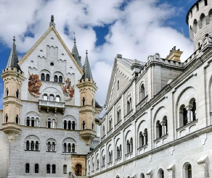 Neuschwanstein Schloss in Bayern mit weißen Mauern und Türmen unter blauem Himmel