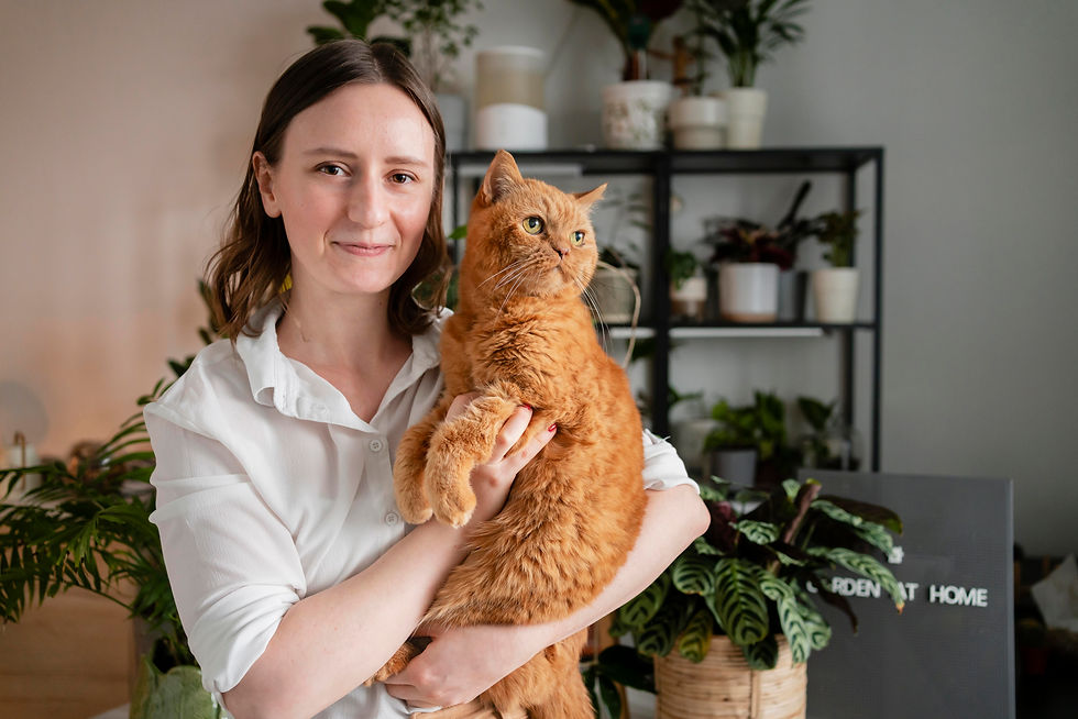 woman-growing-plants-home-holding-cat.