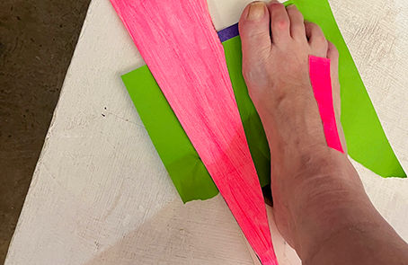 foot with paper drawings on floor