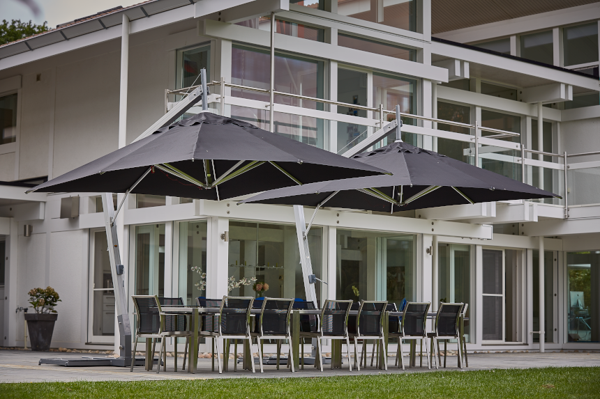 Two heavy-duty cantilever parasols over a patio dining set.