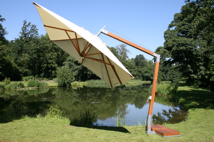 Levante side wind bamboo parasol tilted over a pond