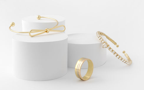 Golden girl accessories two golden bracelets and ring on white background.jpg