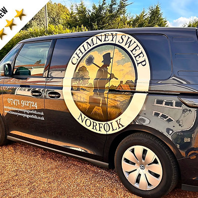 Side view of a dark blue van wrapped with a circular graphic design parked on gravel