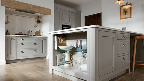 Side view of a grey kitchen island with integrated glass display shelving.