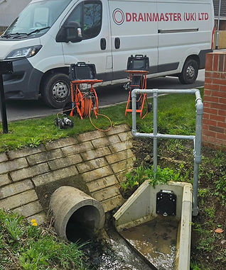 Drainage inspection equipment parked near a concrete culvert outlet
