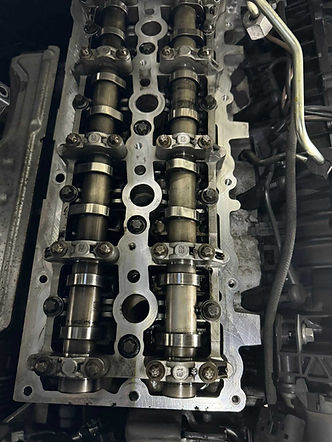 Detailed close up of dual overhead camshafts and valves inside an open internal combustion engine block