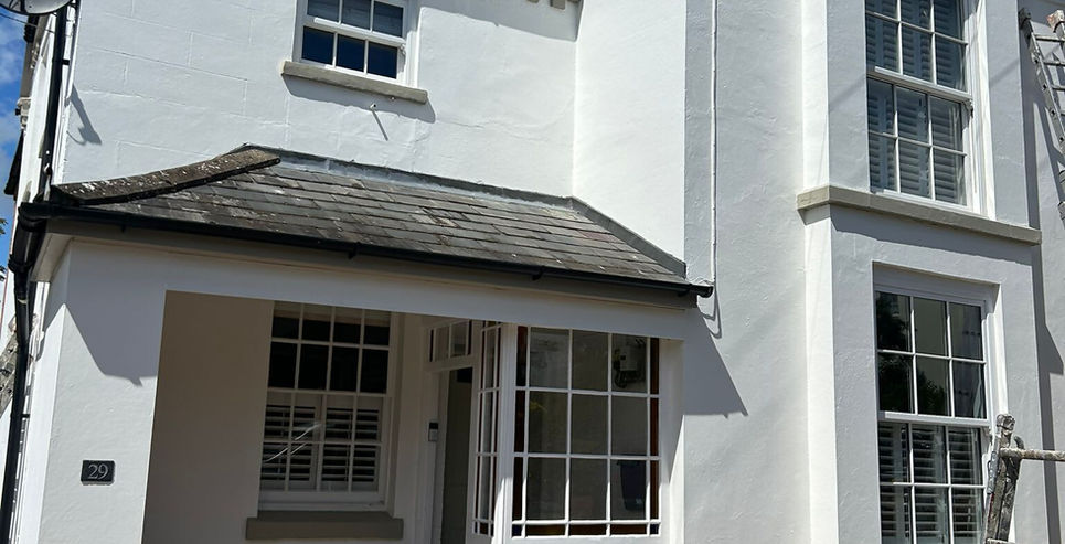 Bright white two-story house with a brick paved patio