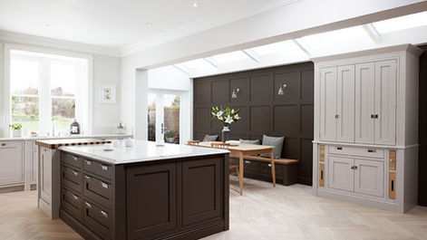 Large open kitchen featuring a dark brown island and a grey dresser.