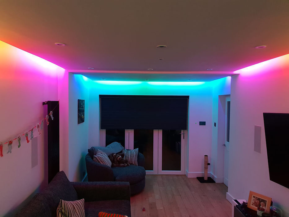 Modern living room featuring vibrant colour changing smart LED strip lighting along the ceiling edge