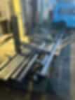 Stack of freshly fabricated black metal posts and structural steel beams on an outdoor pallet