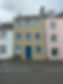 Row of colourful painted house facades featuring pastel shades and white sash windows