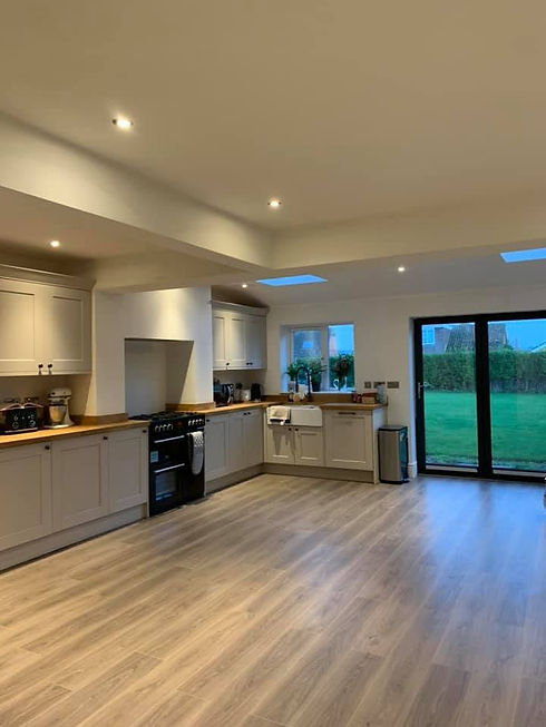 Spacious open plan kitchen extension with skylights and bifold doors opening to garden
