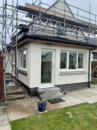 Small modern house extension with white walls, three windows, and a glass door