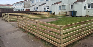 Long residential timber panel boundary fence installed alongside a paved garden walkway