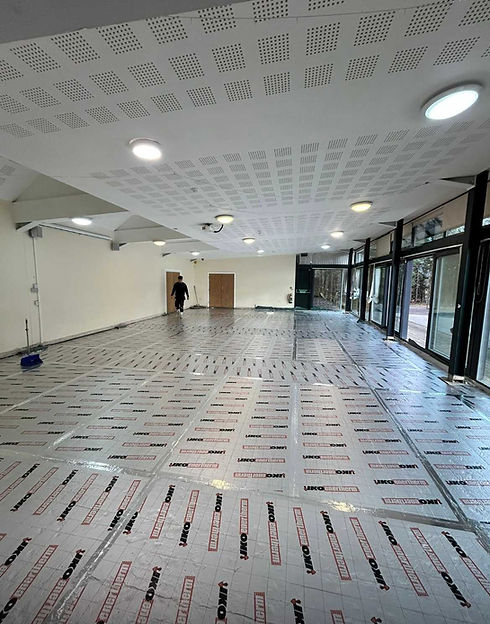 Underfloor heating pipe installation laid across a large open-plan room floor before screeding