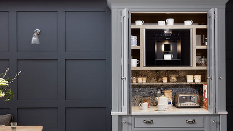 Built-in breakfast station cabinet open to reveal integrated coffee machine setup.