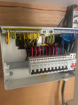 An open electrical panel displays neatly arranged wires in various colors