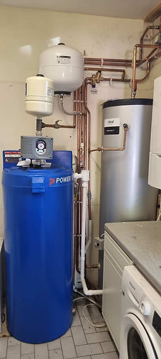 A utility room with a blue Power pump and a silver Ideal hot water cylinder