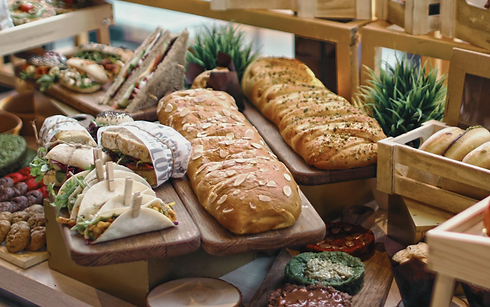 Različni prigrizki in pekovski izdelki pripravljeni za catering na dogodku.