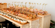 Kanapeji in finger food na lesenem catering pultu
