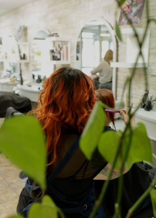 Femme aux cheveux roux chez le coiffeur.