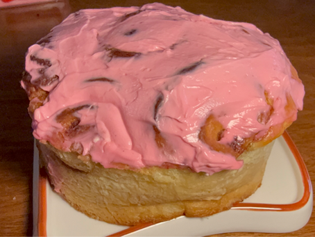 Cinnamon roll cake with pink cream cheese frosting