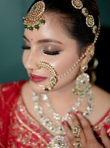 Indian bride wearing elaborate gold and green bridal jewelry