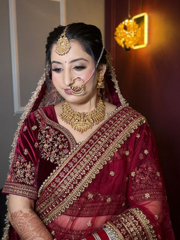 Woman in red Indian bridal outfit and gold jewelry